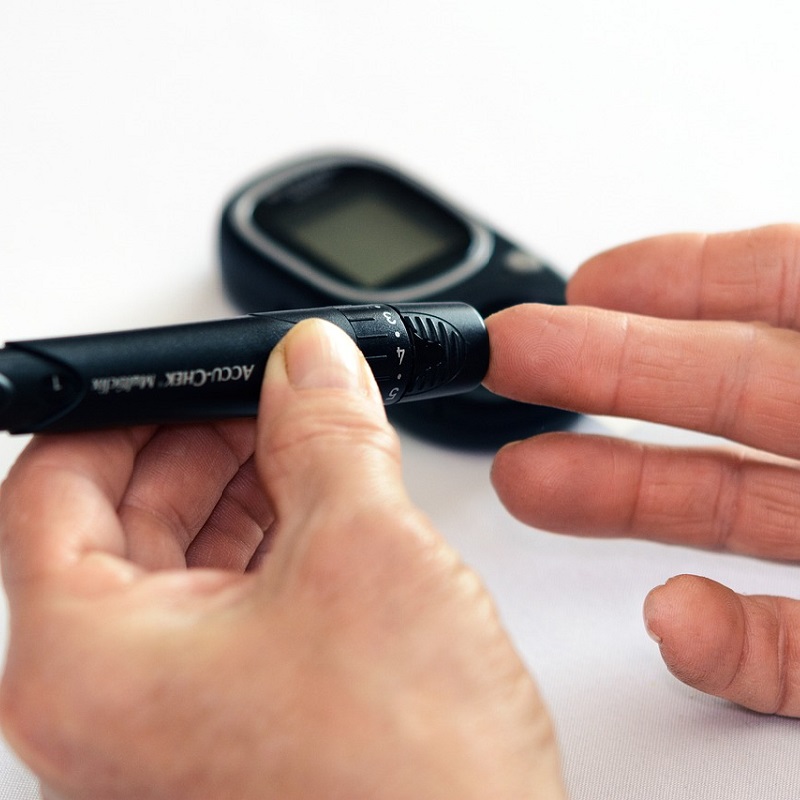 A person pricks their finger to perform a blood glucose test.